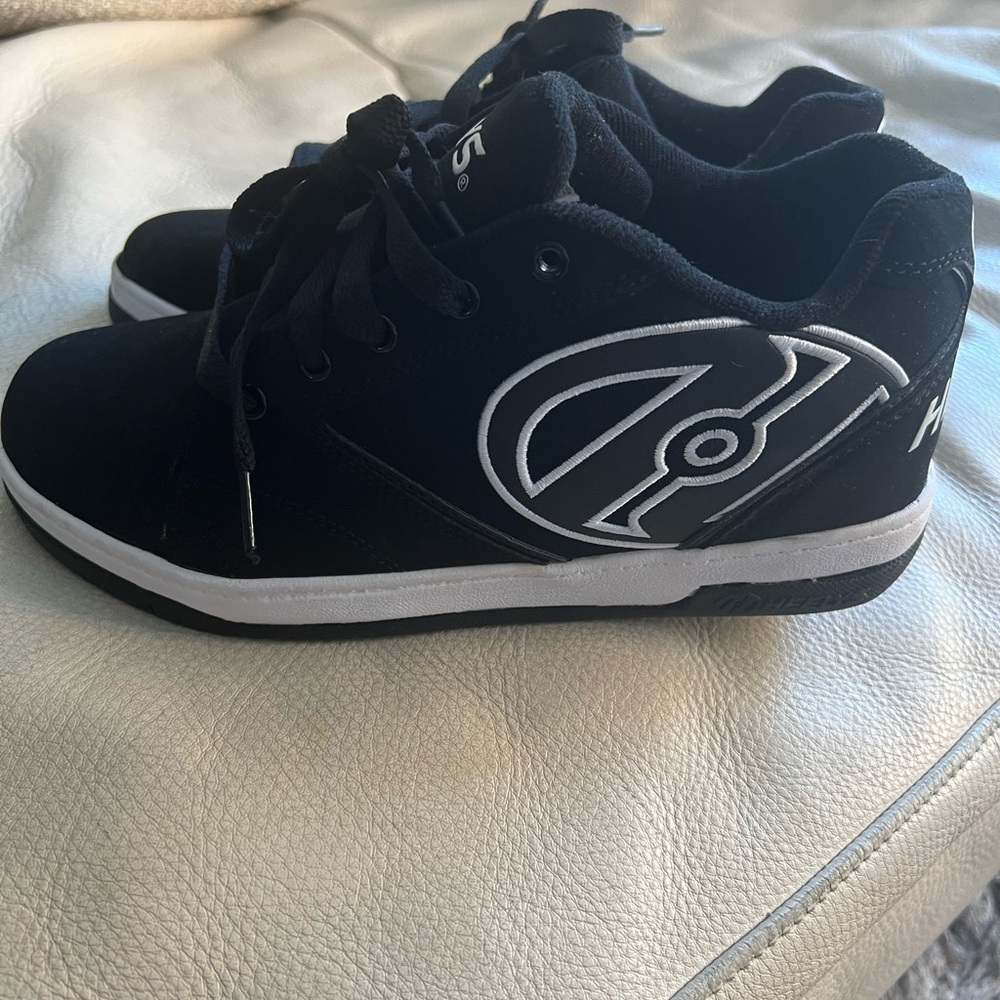 Heely’s size 7, black sneakers with back wheels.